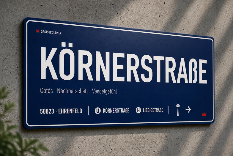 Frontansicht des Aluminium-Designschilds. Das Aluminium-Designschild „Körnerstraße“ von DasIstColonia in Dunkelblau mit weißer Typografie an einer Betonwand. Design Straßenschild für Köln-Liebhaber